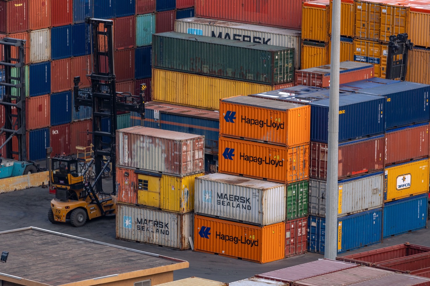 Stacked shipping containers and forklifts
